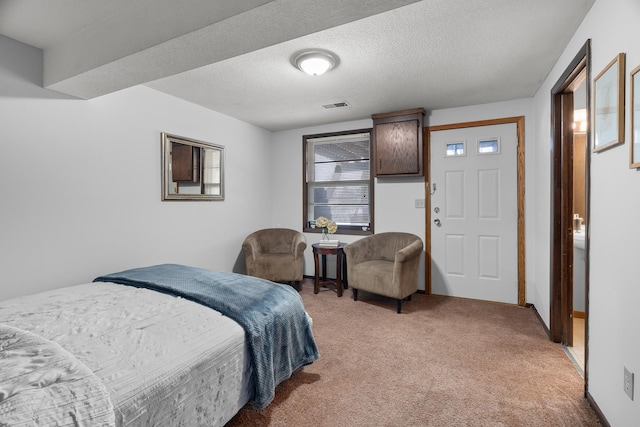 bedroom with a textured ceiling, visible vents, and light colored carpet