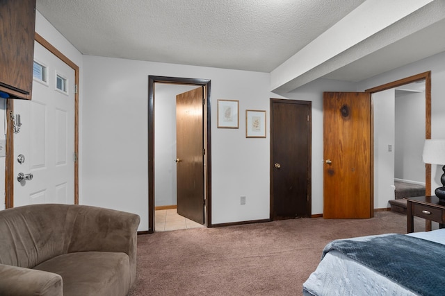 bedroom with a textured ceiling, baseboards, visible vents, and light colored carpet