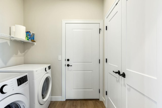 washroom with dark hardwood / wood-style flooring and washing machine and clothes dryer