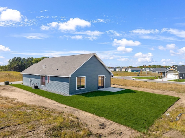 back of property with a yard and central AC unit