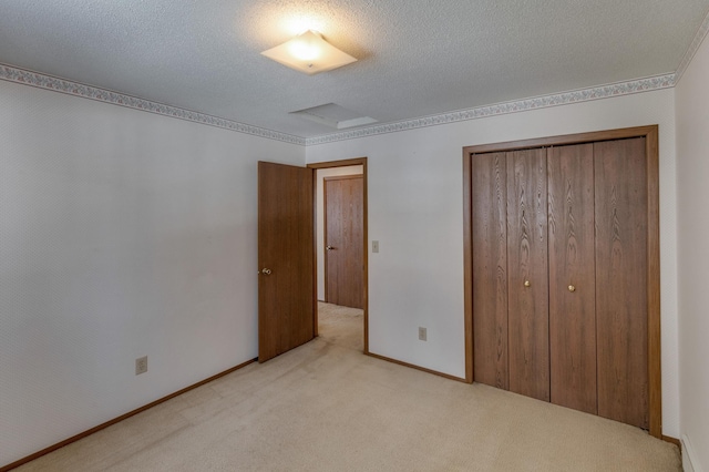 unfurnished bedroom with light colored carpet, a closet, and a textured ceiling