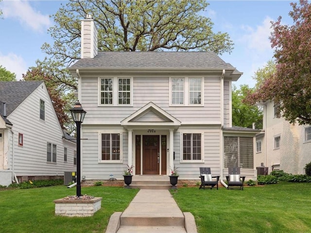 view of front of property featuring central AC and a front lawn