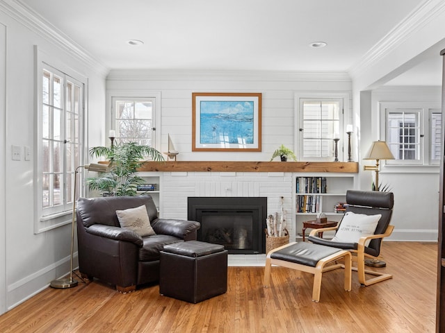 sitting room featuring hardwood / wood-style flooring, a fireplace, and crown molding