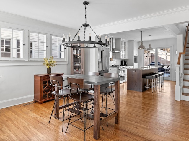 dining room featuring crown molding and light hardwood / wood-style floors