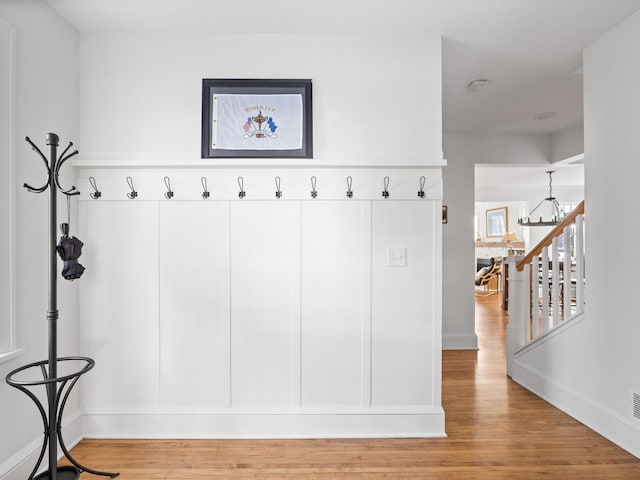 mudroom featuring a notable chandelier and light wood-type flooring