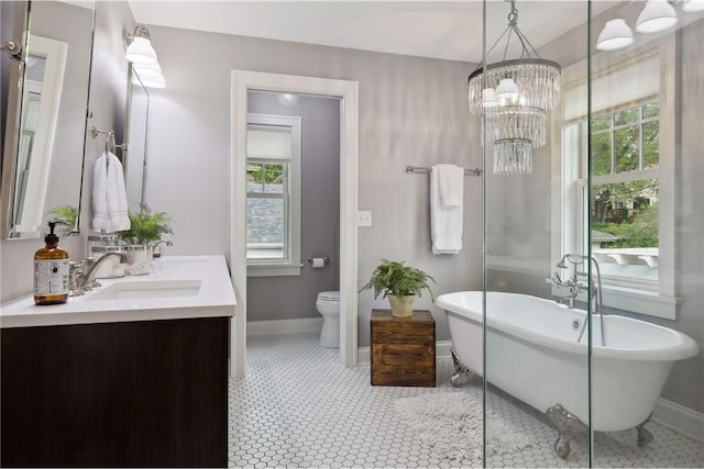 bathroom with vanity, a tub, a wealth of natural light, and toilet