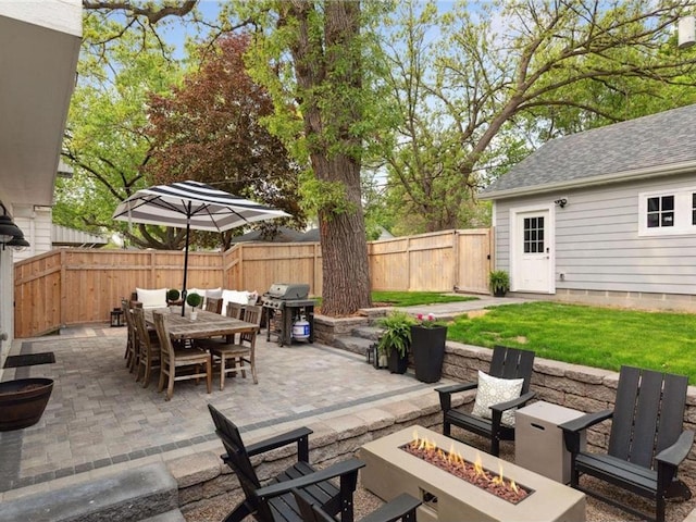 view of patio with an outdoor fire pit and a grill