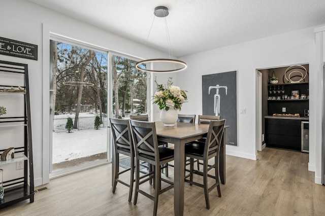 dining space featuring a textured ceiling and light wood-type flooring