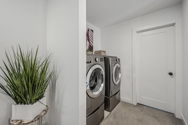 laundry area with light carpet, independent washer and dryer, and a textured ceiling