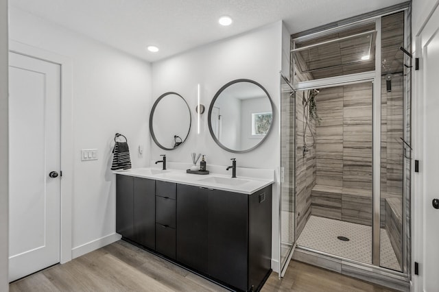 bathroom with hardwood / wood-style flooring, vanity, and walk in shower