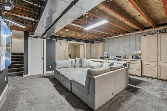 basement featuring a barn door and carpet flooring