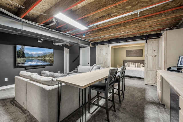 basement with dark carpet and a barn door