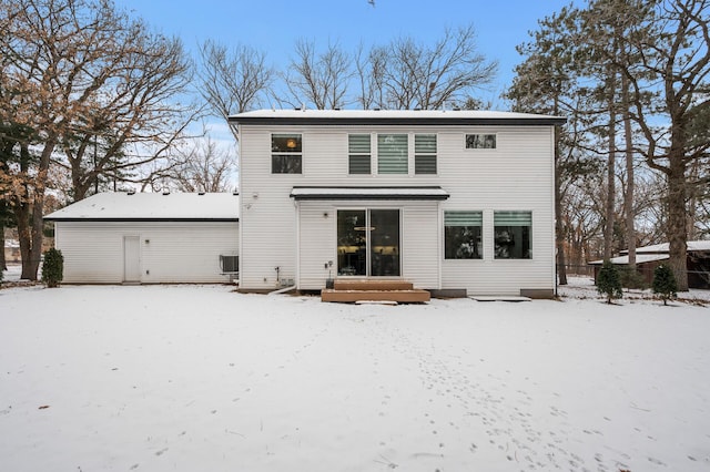 snow covered house featuring central AC unit