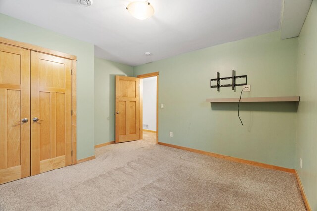 unfurnished bedroom with a closet and light carpet