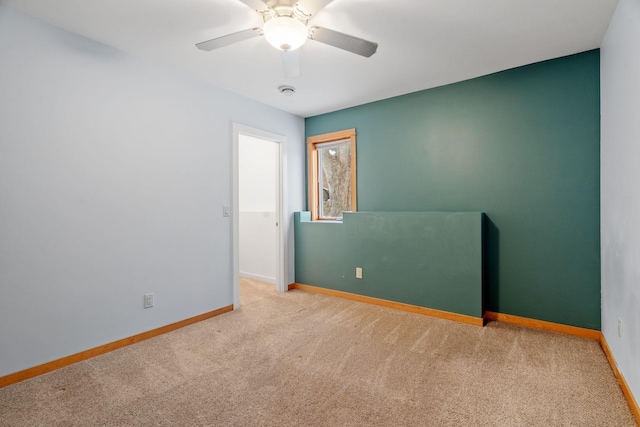 unfurnished room featuring light carpet and ceiling fan