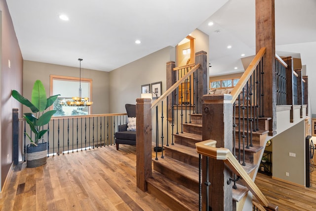 stairway featuring hardwood / wood-style flooring and an inviting chandelier