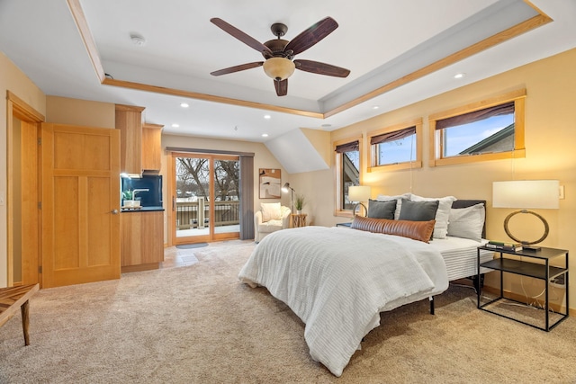 bedroom featuring access to outside, light colored carpet, ceiling fan, and a tray ceiling