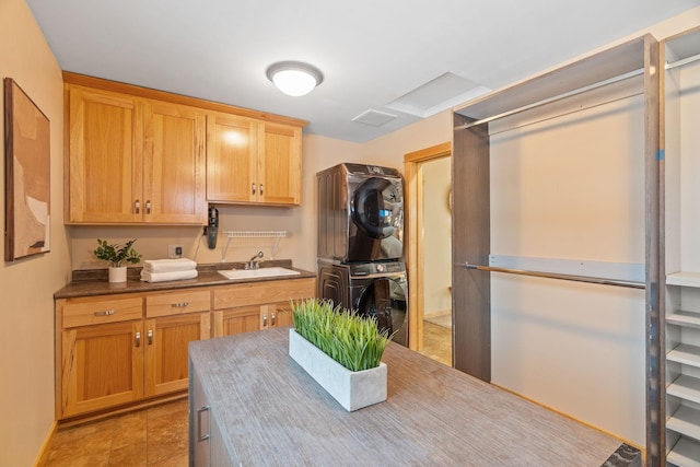 kitchen featuring stacked washer and dryer and sink