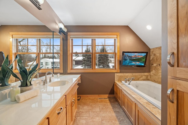 bathroom with vaulted ceiling, vanity, and a tub to relax in