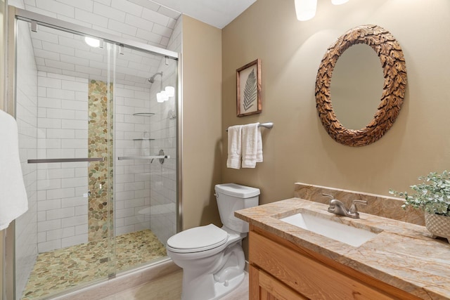 bathroom with walk in shower, vanity, and toilet