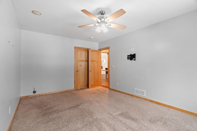 carpeted empty room featuring ceiling fan