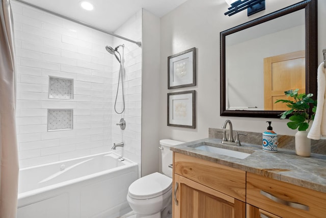 full bathroom with vanity, tiled shower / bath combo, and toilet