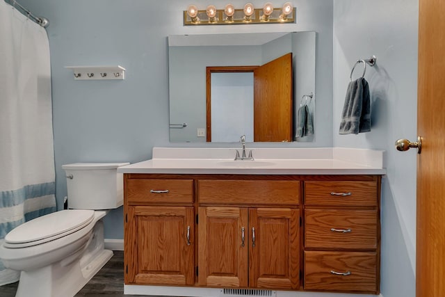 bathroom featuring vanity, hardwood / wood-style flooring, and toilet