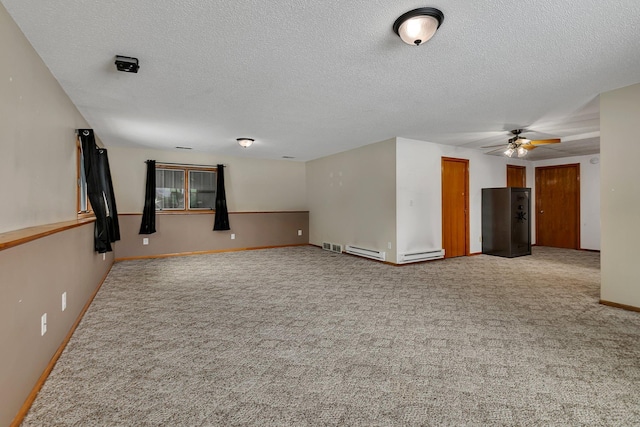 empty room featuring ceiling fan, carpet floors, a textured ceiling, and baseboard heating