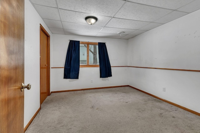 spare room with light carpet and a drop ceiling