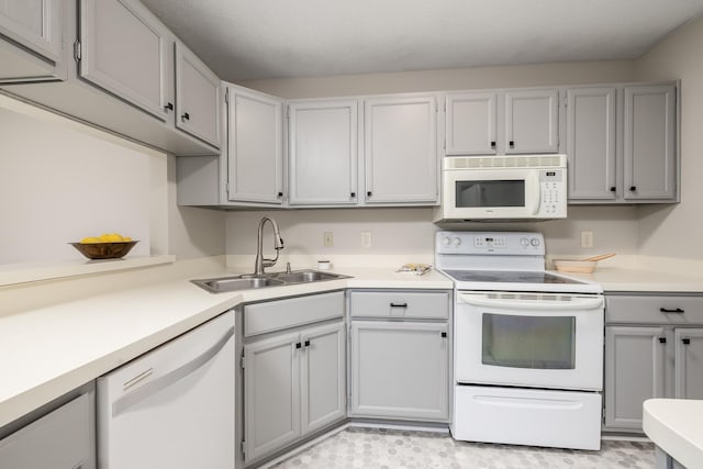 kitchen with sink, white appliances, and gray cabinets