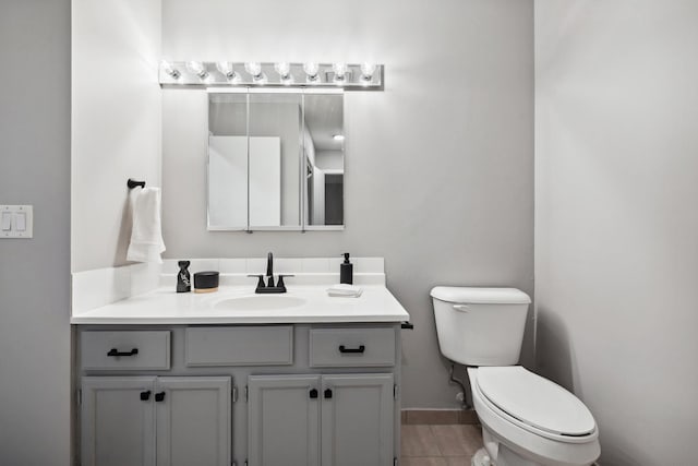 bathroom featuring tile patterned flooring, vanity, and toilet