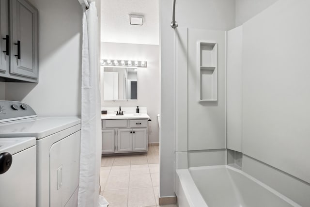 laundry area featuring separate washer and dryer, sink, light tile patterned floors, and a textured ceiling