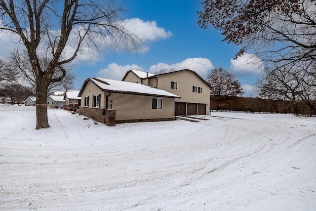 snow covered property featuring a garage