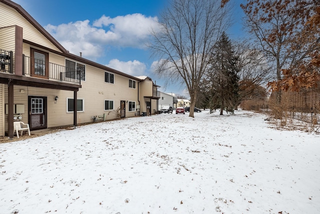 yard covered in snow with a balcony