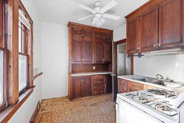 kitchen featuring sink, white gas range oven, and ceiling fan