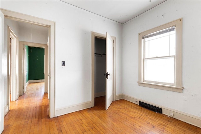 unfurnished bedroom featuring light hardwood / wood-style floors and a closet