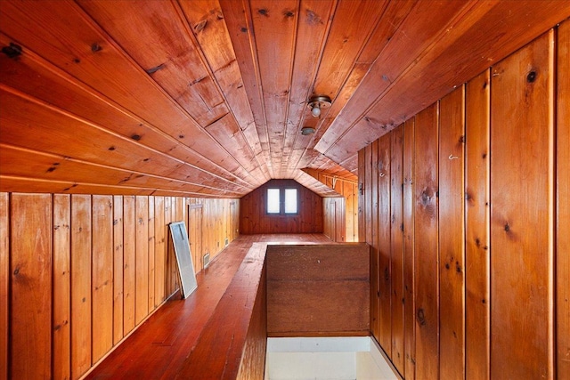 additional living space with light hardwood / wood-style flooring, wood ceiling, vaulted ceiling, and wood walls