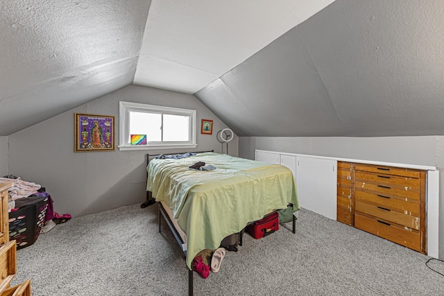 bedroom with lofted ceiling, carpet, and a textured ceiling