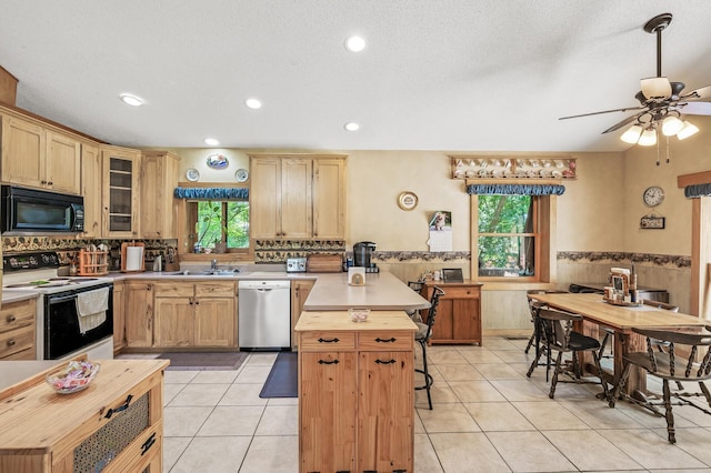 kitchen with light tile patterned floors, a breakfast bar, range with electric cooktop, a kitchen island, and stainless steel dishwasher