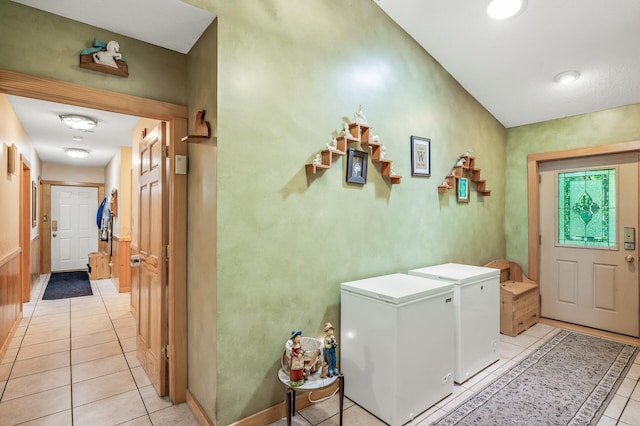 laundry area featuring washer and dryer and light tile patterned flooring