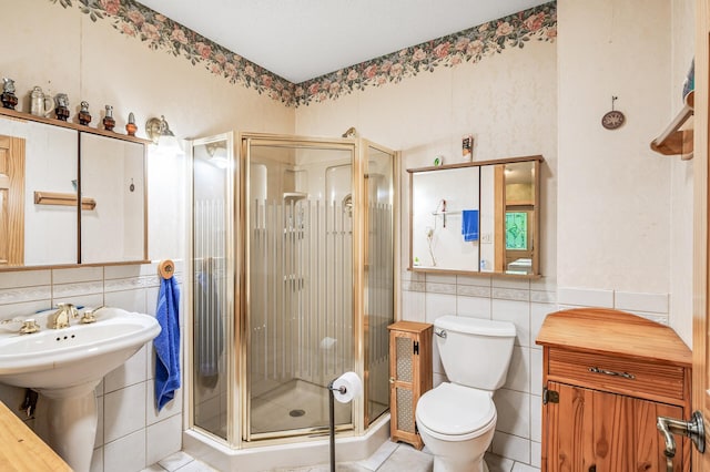 bathroom featuring tile walls, tile patterned flooring, toilet, and walk in shower