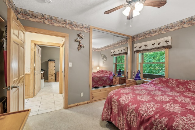 bedroom with light carpet, ceiling fan, and a textured ceiling