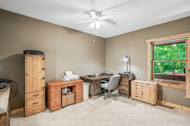 carpeted office with a textured ceiling and ceiling fan