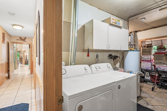 clothes washing area with cabinets, light tile patterned floors, independent washer and dryer, and water heater