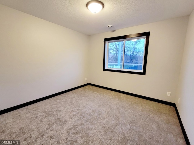 carpeted spare room with a textured ceiling