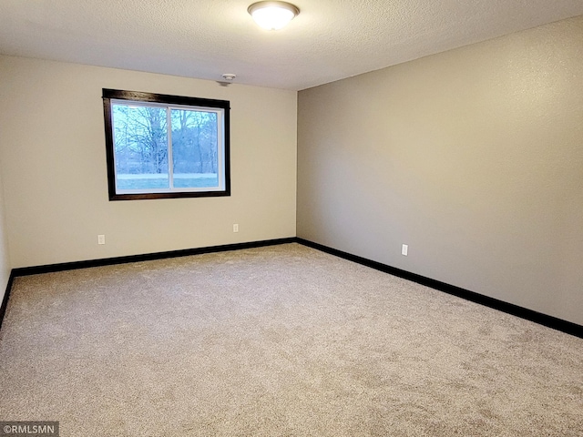 unfurnished room featuring a textured ceiling and carpet