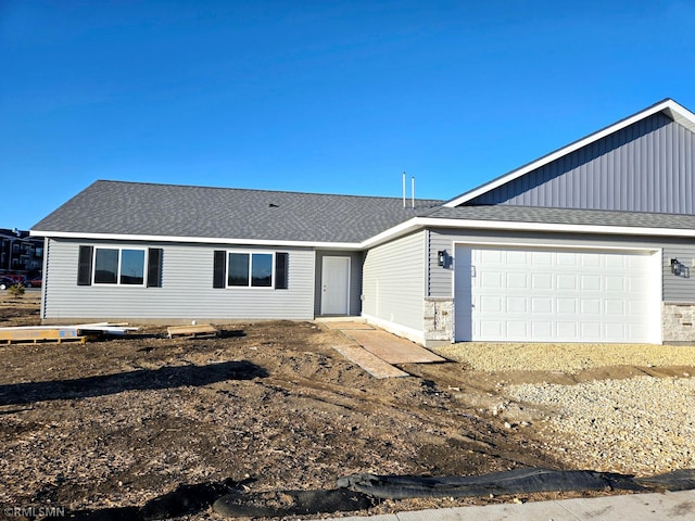 ranch-style house featuring an attached garage and a shingled roof