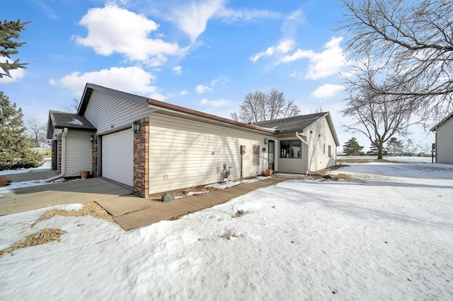 snow covered property with a garage