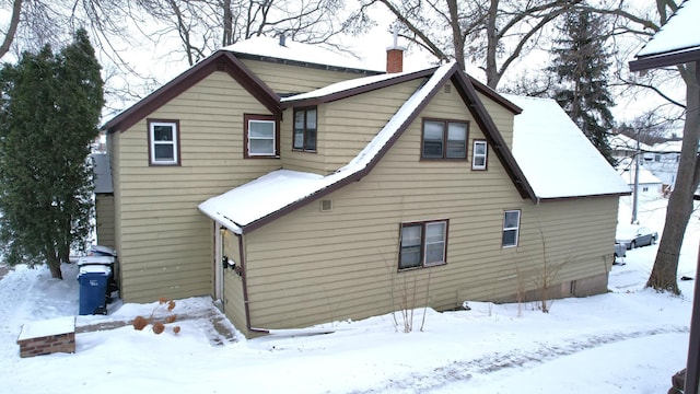 view of snow covered back of property