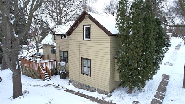 snow covered property with a wooden deck